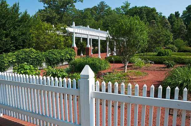 The ubiquitous white picket fence in front of a classic New England home in the suburb of Wellesley, MA, just outside of Boston, MA.