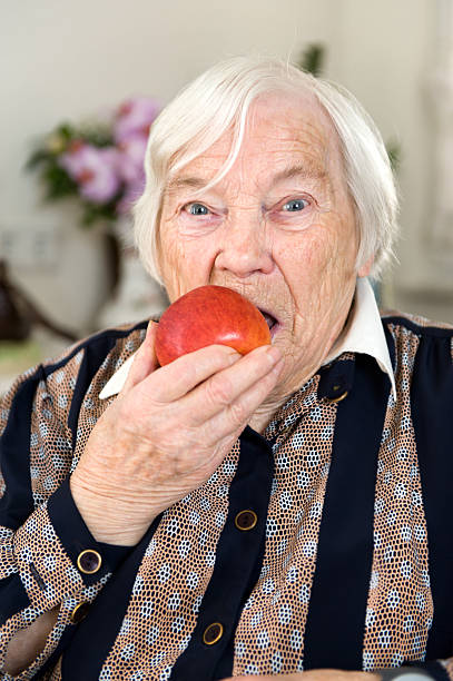 istock Female senior holding a ripe apple in her hand 171152306