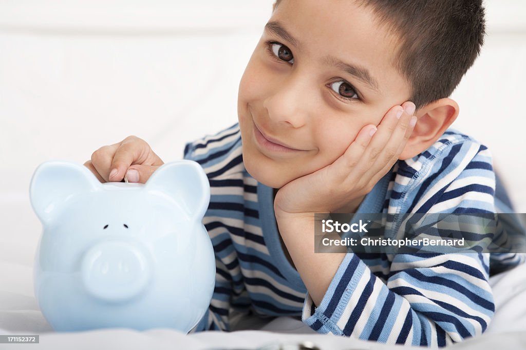 Lächelnde junge putting Geld im Sparschwein - Lizenzfrei 6-7 Jahre Stock-Foto