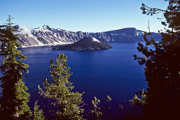 Crater Lake and Wizard Island Crater Lake exists in the blown-out caldera of a once mighty volcano known as Mount Mazama. This view of the lake and Wizard Island was taken from West Rim Drive in Crater Lake National Park, yyy, USA. jeff goulden crater lake national park stock pictures, royalty-free photos & images