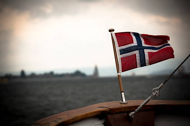 Norwegian Flag, Sailing in Norway. Location: Oslo Bay, North Sea, Scandinavia. Digital noise added for the mood, grainy.