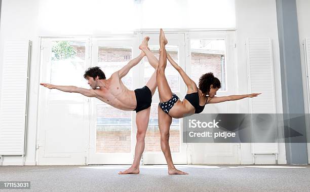 Man And Woman Performing Standing Bow Pulling Pose Xxxl Image Stock Photo - Download Image Now