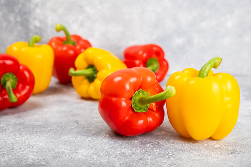 PAPRIKA.Fresh yellow and red bell peppers on a textural background. Bulgarian salad pepper .Fresh vegetables. Harvest. Vegan. closeup. Place for text. copy space.