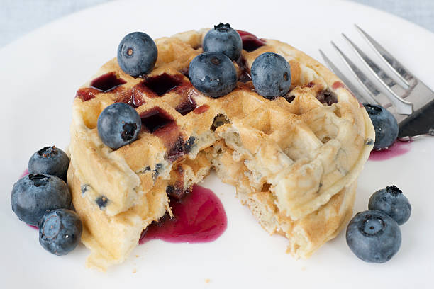 stack of golden waffles with fresh blueberries