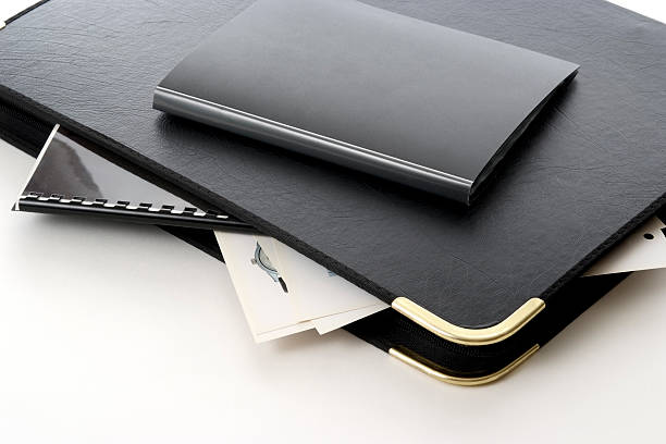 絶縁ショットのポートフォリオ白い背景の上のスタックド - leather folder ストックフォトと画像