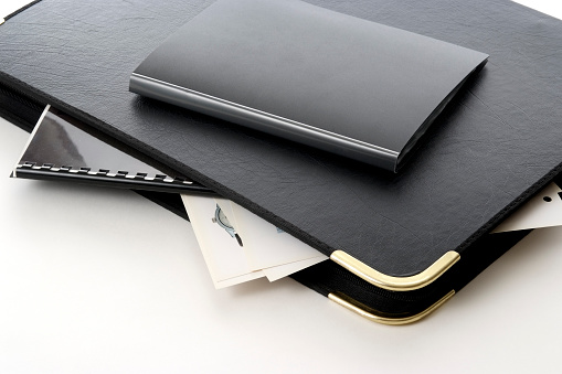 Close-up of stacked portfolio with art works isolated on white background.