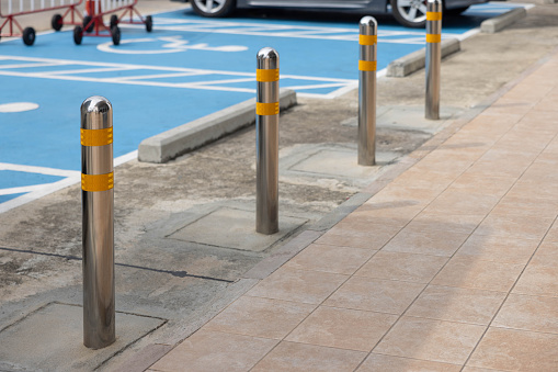 stainless steel bollards on pathway with the disabled parking lots as background.