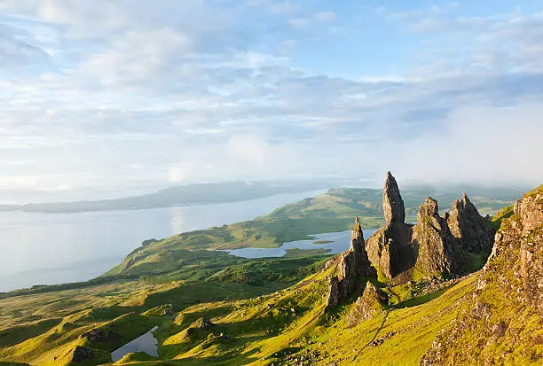 The Storr is a rocky hill on the Trotternish peninsula of the Isle of Skye. The hill presents a steep rocky eastern face overlooking the Sound of Raasay, contrasting with gentler grassy slopes to the west.Overcast day.Picture taken at dawn, first light of the day.