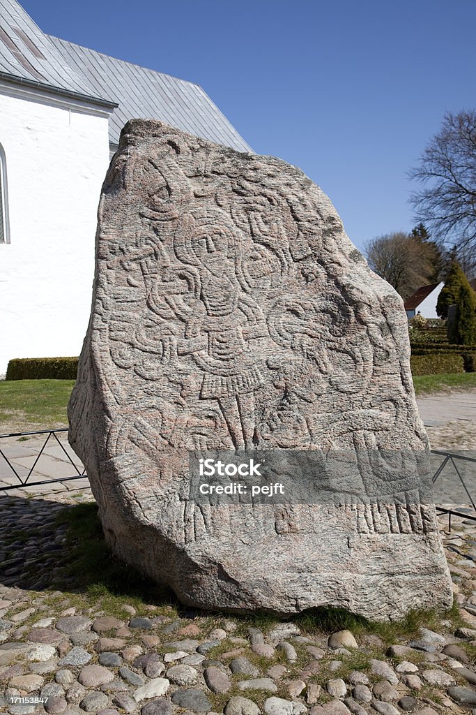 UNESCO World Heritage Denmark's birth certificate the Jelling Runic stone King Harald the Bluetooth runic stone c. 965 AD aa Denmarkaas abirth certificateaAThe Jelling monuments were registered on the World Heritage List because of the unique historical importance of the site.At Jelling you meet the 10th century Viking King, Gorm den Gamle (Gorm the Old) who died in 959 and Queen Thyra as well as their son Harald BlAYtand (Harald Bluetooth) who died in around year 987.The burial mounds, the runic stones and the church are markable example of Nordic pagan culture and illustrate an important role in the history of the area, a unique complex of religious and political manifestations and early Christianity in Scandinavia in the 10th century.The monuments consist of the two runic stones, the medieval church and the two burial mounds.The monuments reflect the transition from paganism to Christianity, and are referred to as Denmarkaas birth certificate, as one of the runic stones carries the oldest inscription referring to Denmark the country and its people athe DanesaA. Stone - Object Stock Photo