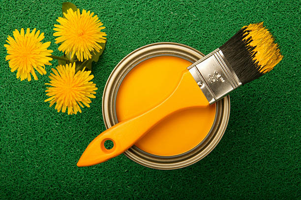 Yellow paint and dandelions on green turf