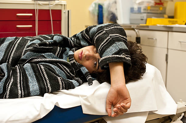 Teenager in a hospital emergency room Teenager in a hospital emergency room looking at the camera, could be for overdose, alcohol, depression, accident or any other medical condition hospital depression sadness bed stock pictures, royalty-free photos & images