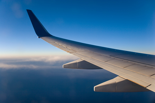 a white business plane takes off against the background of a blue sunny sky