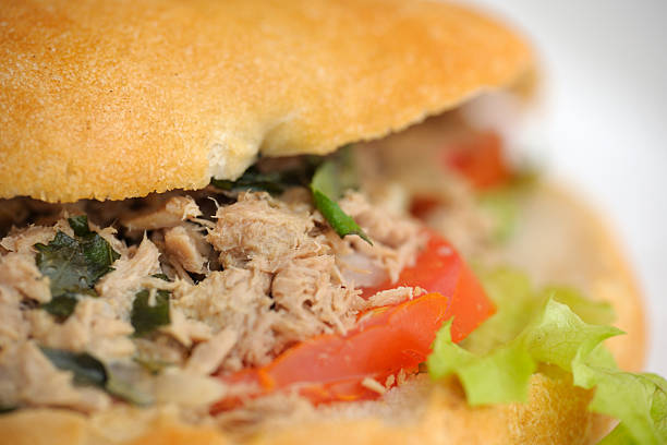 A photo of a cross-section sandwich with chicken nanban and plenty of lettuce.