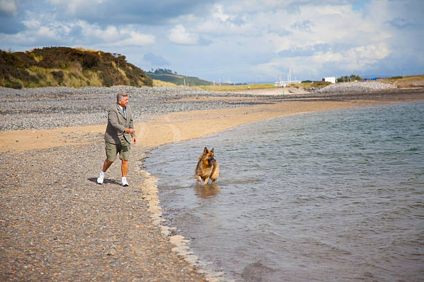 istock busniness man on beach with dog 171155277