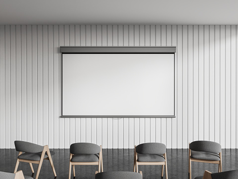 White modern classroom interior with grey armchairs in row, mock up copy space projection screen on wall. Front view of training or conference space with minimalist design. 3D rendering