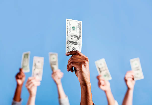istock The mighty dollar! Six hands hold up US currency 171155741
