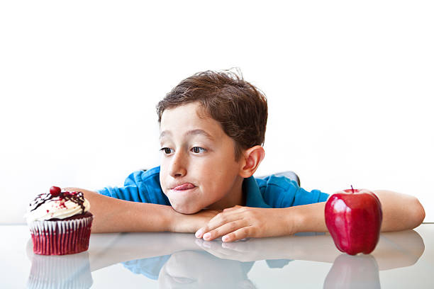 istock Boy choosing between healthy and unhealthy foods. 171155960
