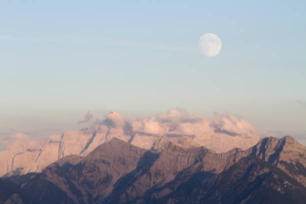 istock rising full moon over mountains 171156226