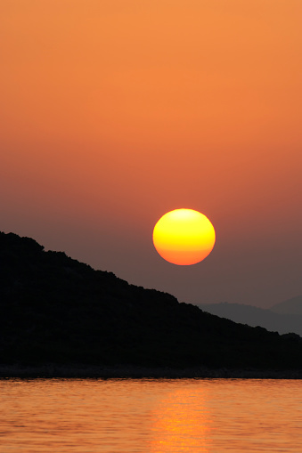 Orange sunset with red to yellow colors of the sun.