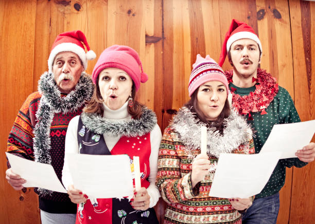 семья петь рождественские песни - caroler стоковые фото и изображения
