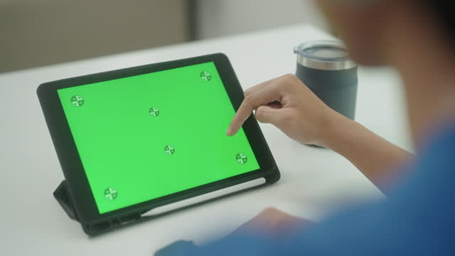 Doctor using digital tablet with green screen.