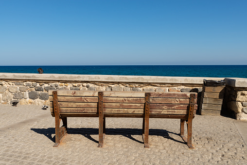 Wooden bench looking over the ocean in Heraklion, Crete, Greece.