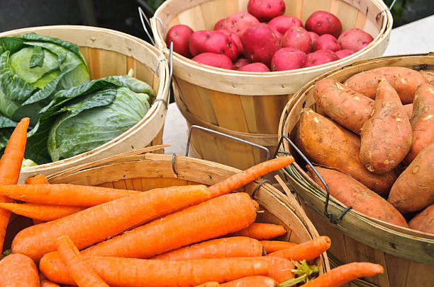 Bushel baskets of carrots, cabbage, red and sweet potatoes offered for sale and a midwinter farmers market on Cape Cod