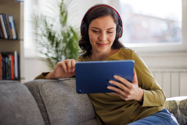 istock Smiling relaxed woman resting on couch using digital tablet 1711589130