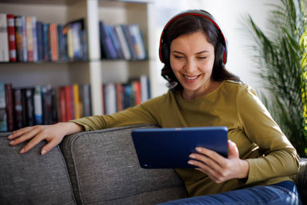 istock Smiling relaxed woman resting on couch using digital tablet 1711589134