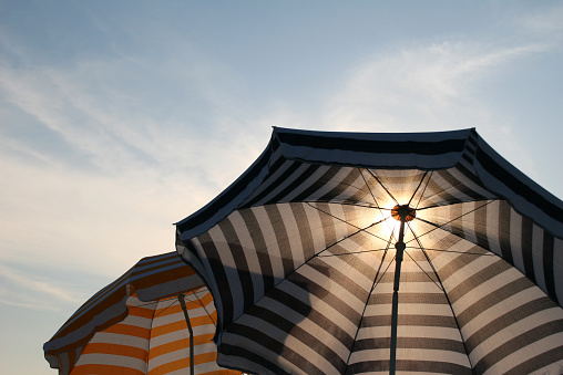 two parasols against sunlight and blue sky