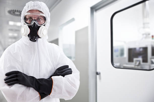 Scientist A scary looking scientist wearing a protective suit with goggles and gas mask. biohazard cleanup stock pictures, royalty-free photos & images