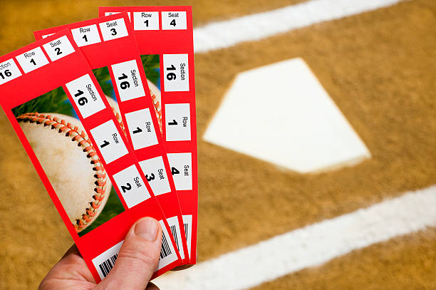 Hand holding Baseball Tickets at home plate A Hand holding three baseball ticket stubs at home plate with the chalk lines of the batter's box sports event stock pictures, royalty-free photos & images