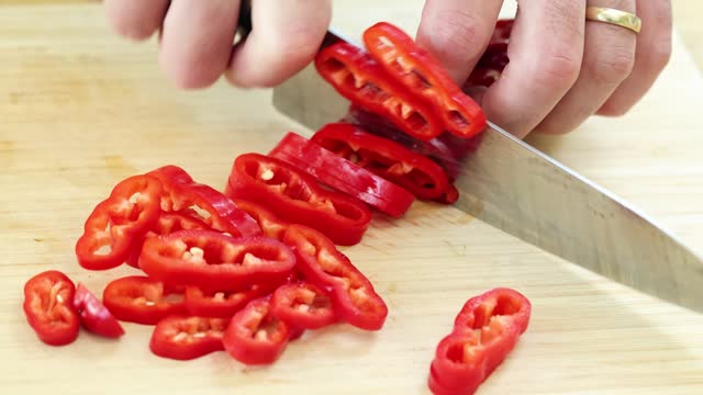 Slicing red pepper on a wooden board