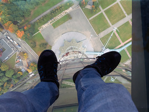Human legs on glass floor at the 1110 ft (248 m) level of Ostankino tv-tower in Moscow, Russia