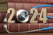 2024 Happy New Year for health care medicine and pharmacy industry. Number 2024 with stethoscope on vintage books of medicine.