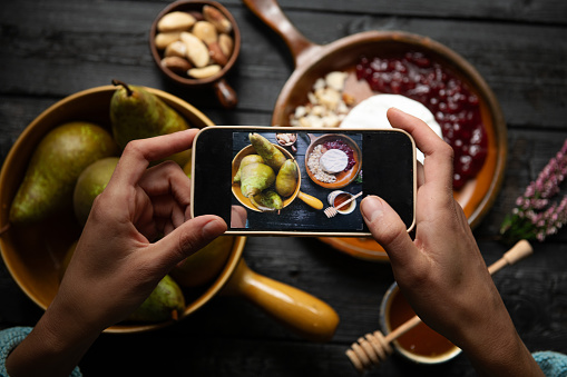 Woman photographing food with her phone