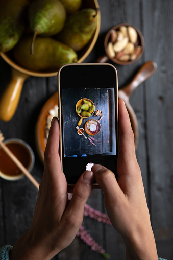 Woman photographing food with her phone