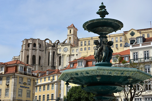 Lisbon, Portugal, 06-14-2022\nRossio square with fountain and cobblestone wave pattern in the center of Lisbon's Baixa