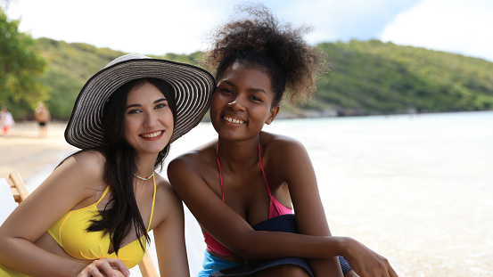 Portrait with and black girl with bikini relaxation on a tropical beach