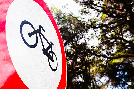 Sign forbidden to ride a bicycle, placed in a forest.
