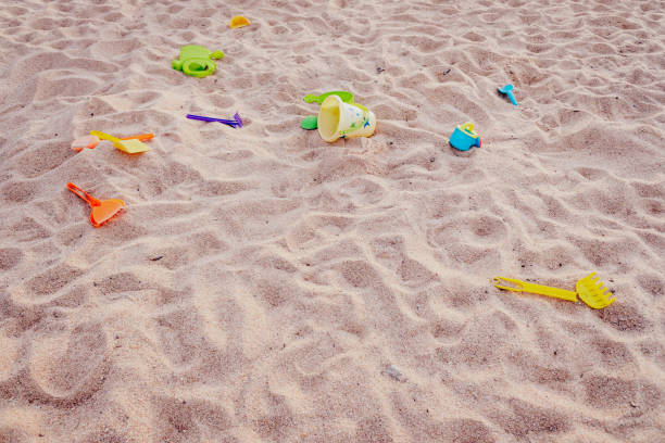 Shovels and plastic toys abandoned in a sandbox, contaminating the park with microplastics.