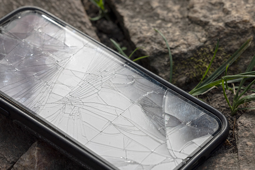 Cell phone lies on the floor with a broken display
