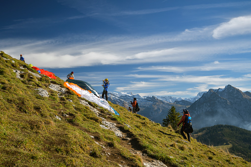 Sattelegg, Switzerland - October 31, 2020: Paragliders preparing to start on top of Chli Aubrig peak in Switzerland during sunny autumn day in October 2020