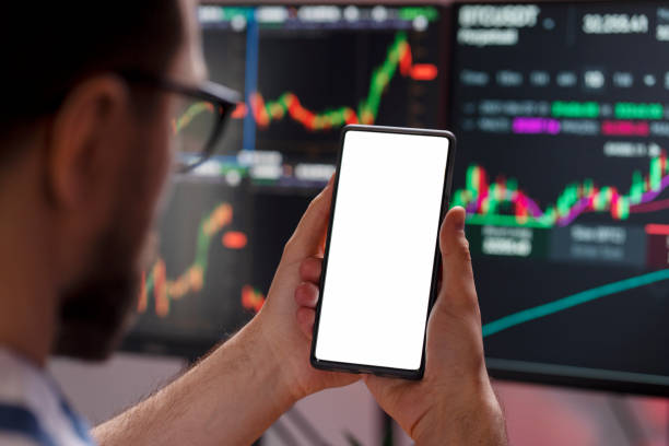 istock Trader holding mobile phone looking at screen with mockup, selective focus. Online trading concept 1711802316