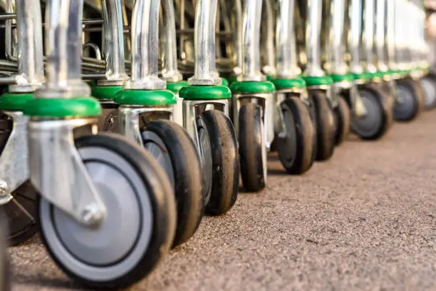 Detail of the plastic wheels of shopping carts in a supermarket lined up.