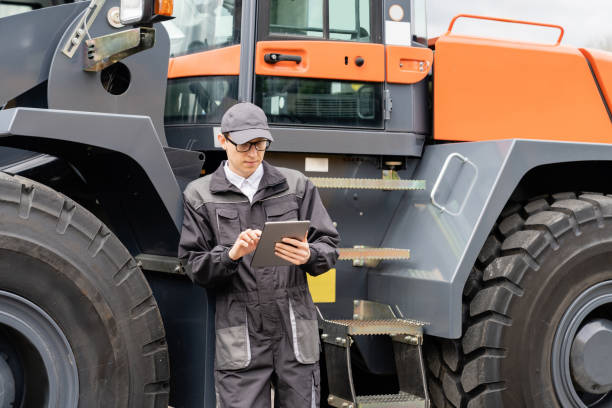istock Serviceman with digital tablet next to the tractor. 1711850474