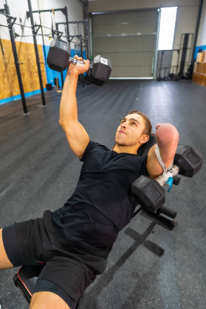 istock Strong disabled man exercising with dumbbells in a bench 1711855913