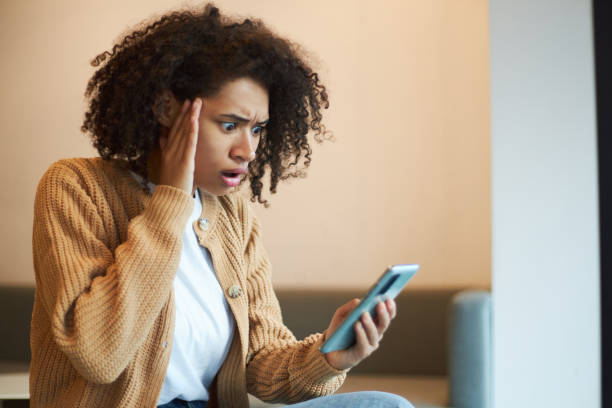 istock Stupefied African American woman expressing shock and astonishment while checking her mobile phone 1711858862