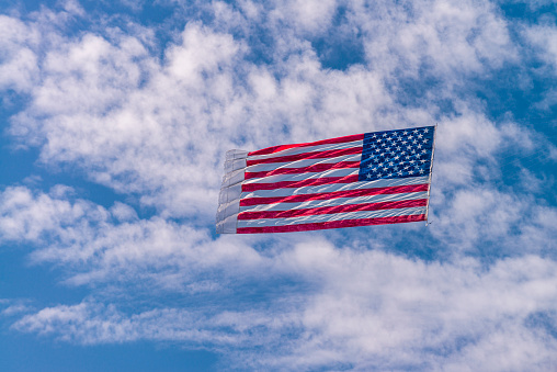United States of American flag on display against a cloudy sky