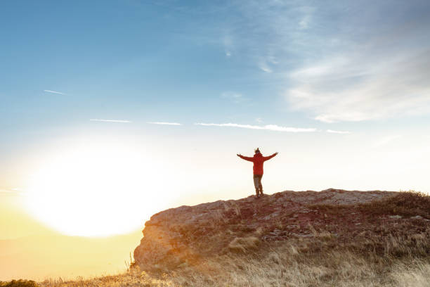 istock Female hiker stands arms outstretched on mountain top 1711863241